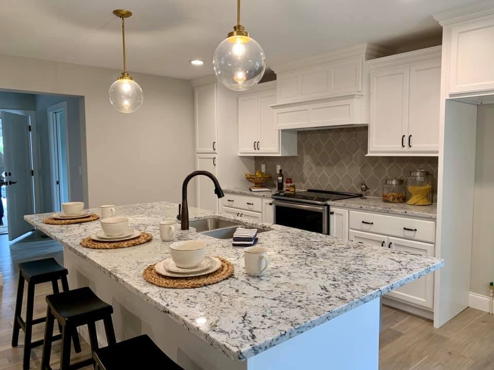 Vacant staging, Brookshire new build: white shaker kitchen with a granite island and glass globe pendants